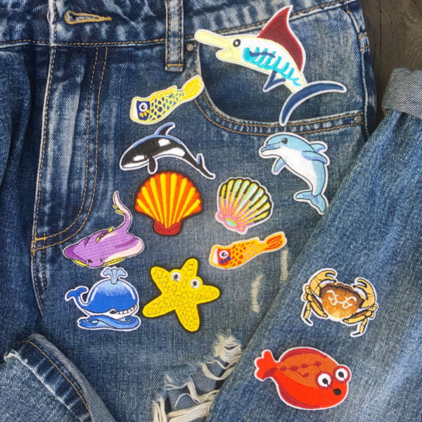 Tygmärken placerade på jeans föreställande havsdjur