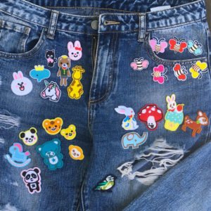 Flera tygmärken placerade på jeans föreställande gulliga djurmotiv