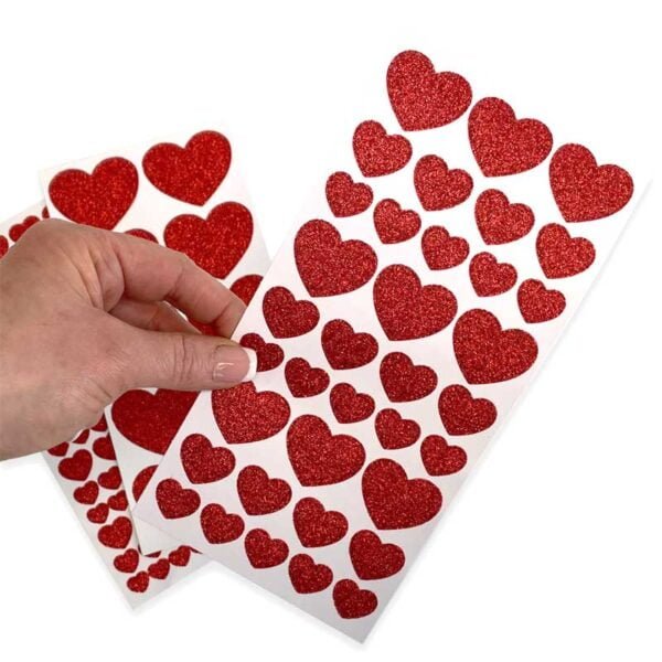Stickers i form av röda glittriga hjärtan i flera storlekar