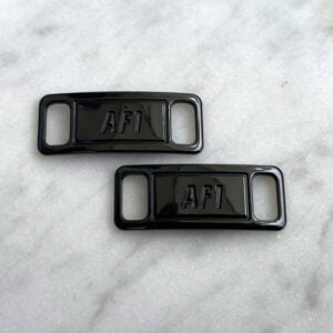 Ett par AF1 spännen i blank svart metall